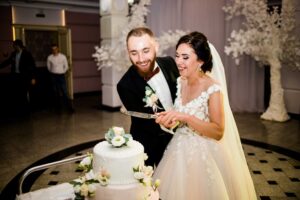 Bride and groom cutting the wedding cake together