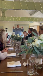 Wedding host entertaining guests before introducing the bride and groom to the wedding breakfast